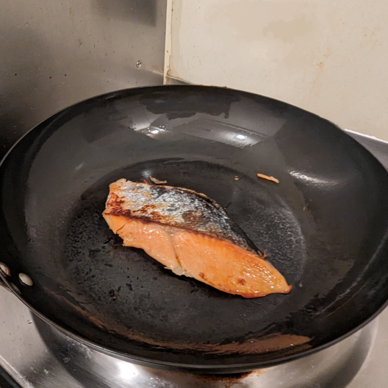 キッチンのひとくちコンロにリバーライト極JAPANフライパンをかけ、鮭を一匹焼いている画像。

鮭の皮目にはパリッと焼き色が付いている。