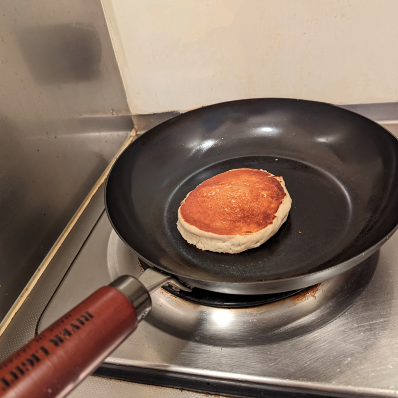 キッチンのひとくちコンロでリバーライト極フライパンを使ってホットケーキを焼いた画像。フライパン中央にきつね色に焼き上がったホットケーキが写っている。